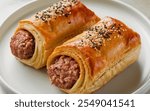 Sausage Rolls: Flaky puff pastry filled with seasoned sausage meat, baked until golden and crispy.