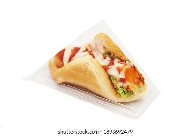 A Sausage Sandwich With Ketchup And Mayonnaise Wrapped In Plastic Packaging And Placed On A White Background. Fast Food, Bread, And Breakfast Ideas.