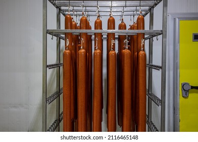 Sausage in smokehouse smoked sausage-meat, smoked meat, ribs, blood sausage, The process of smoking hanging sausages. It sticks salami or sausages hanging on the ropes in the refrigerator.