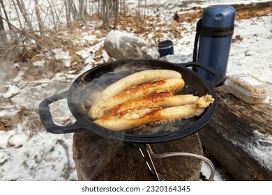 Sausages in bowler in the forest in winter. Camping food making. Foods in outdoor activities. - Powered by Shutterstock