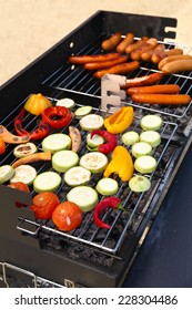 Sausages and vegetables on barbecue grill, close-up - Shutterstock ID 228304486