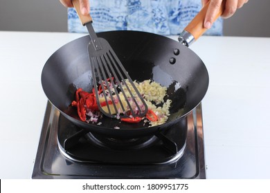 Saute Onion, Garlic, Adn Chilli In The Black Wok Pan. Cooking Process Making Delicious Food 