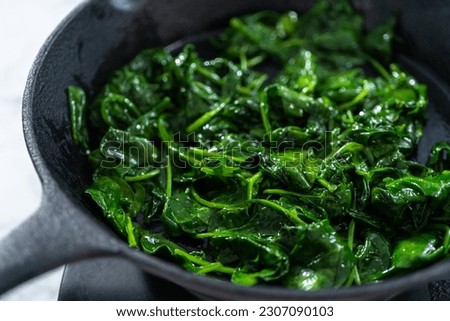 Sauteeing spinach for spinach and ham frittata.