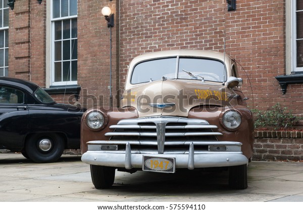SAVANNAH, GEORGIA, UNITED STATES - December 1,\
2013: Old police cars are parked outside the Savannah-Chatham\
Metropolitan Police Department\
Building