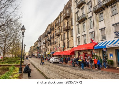 SAVANNAH, GEORGIA, USA - JANUARY 17, 2015 : Historic Buildings, Shops And Restaurants In The River Street Along The Broad Savannah River With Many Walking People.