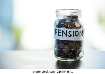Save every dime and dollar. Shot of a pension money jar on a table at home.