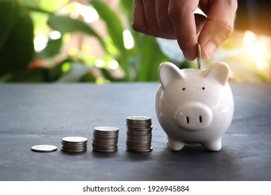 Save money : male hand putting a coin into piggy bank. Piggy bank saving concept. Save money for prepare in the future.