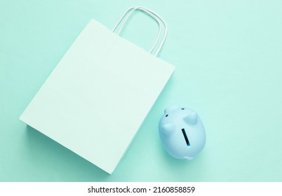 Save Money, Sale Concept. Shopping Bag With Piggy Bank On Blue Background. Top View