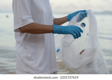 Save ocean. Volunteer pick up trash garbage at the beach and plastic bottles are difficult decompose prevent harm aquatic life. Earth, Environment, Greening planet, reduce global warming, Save world - Powered by Shutterstock