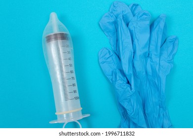 Save Vaccine, Anti Vaccination Concept - Syringe in a Condom Lay on Blue Table in Clinic or Hospital. Mistrust of Vaccination. Natural Immunity. Skepticism About the Vaccine. Freedom and Human Rights
