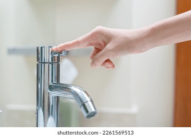 Save water. Volunteer keeps turning off the running water in the bathroom to protect environment. Greening planet, reduce global warming, Save world, life, future, risk energy, crisis , water day. - Shutterstock ID 2261569513