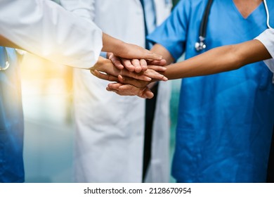 In it to saves lives together. Shot of a group of unrecognisable medical practitioners joining their hands together in unity. - Shutterstock ID 2128670954