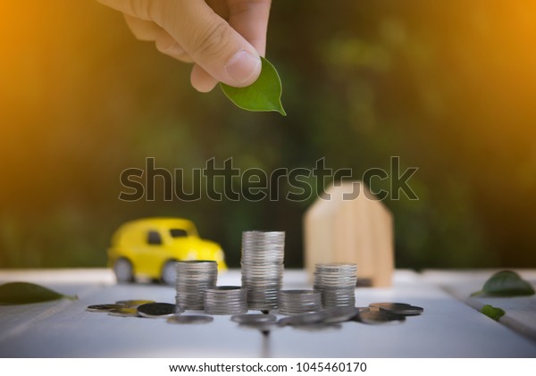 Saving to buy a house or\
car savings concept with money coin stack growing.Saving money\
concept.