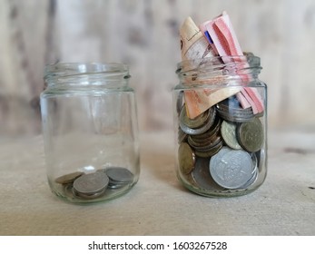 Saving Concept. 2 Jars Of Coins On Wooden Table. 