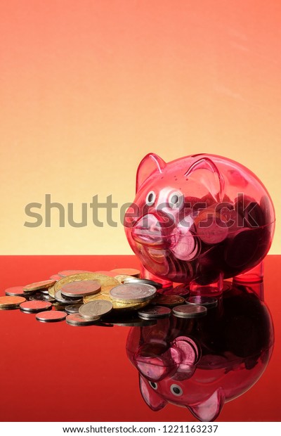 SAVING\
CONCEPT: A red piggy bank on a orange\
background.