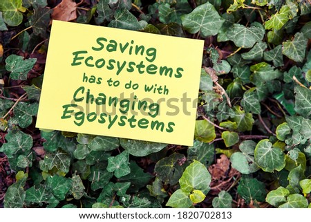 Saving ecosystem has to do with changing egosystem quote written on paper on green garden and leaf background. Environmental preservation and human consciousness concept.