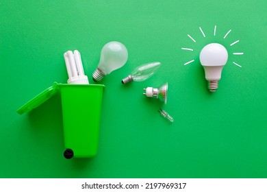 Saving Electricity Concept: Bright New Energy Saving Led Lightbulb Versus Diverse Old Inefficient Light Bulbs On Their Way Into A Green Recycling Bin.