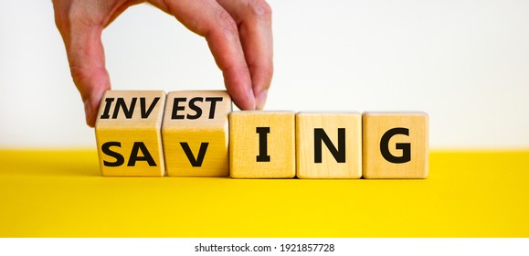 Saving or investing symbol. Businessman turns cubes and changes the word 'investing' to 'saving'. Beautiful yellow table, white background, copy space. Business and saving or investing concept. - Shutterstock ID 1921857728