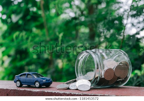 Saving money to buy a dream\
car. Toy cars and artificial light. Concept of saving money. Money\
stack for business planning investment. Investment and saving\
concept