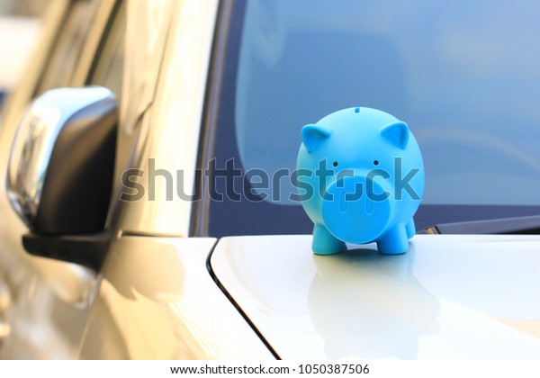 Saving money for car concept, Blue piggy\
standing on the car, Auto\
business