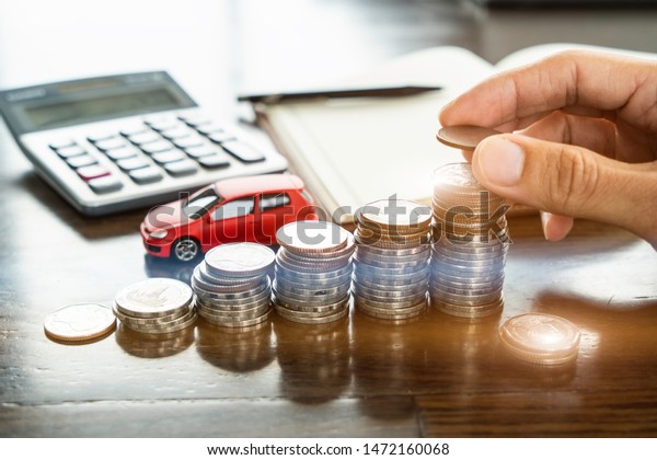Saving money, car loan
concept.  Miniature red car model, coins stack, calculator, pen,
notebook papers