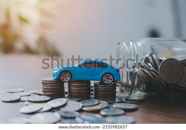 Saving money for a car or material design\
concepts. Miniature car model and Financial statement with coins.\
Finance and banking\
concept