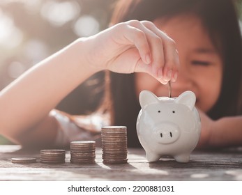 Saving Money Concept. Happy Asian Child Girl Save Money By Putting Coins Into Piggy Bank, Coin Stack Growing. Concept Save Money, Cash, Education, Growth, Finance, Bank, Management, Income, Business