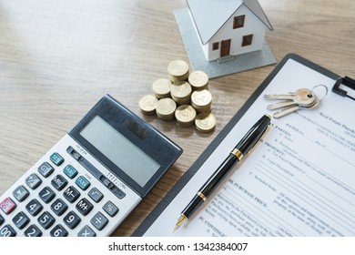 Saving money for house and real estate. Woman hand protecting on stack coins and house model on table. - Shutterstock ID 1342384007