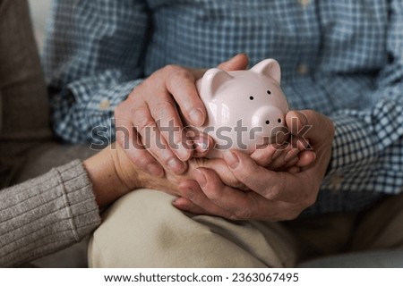 Saving money investment for future. Senior adult mature couple hands holding piggy bank with money coin. Old man woman counting saving money planning retirement budget. Investment banking concept Foto stock © 