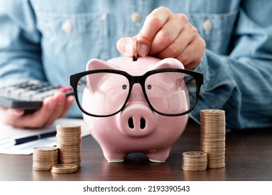 Saving money. Putting money into piggy bank. Managing household budget. Calculating income and expenditure. - Shutterstock ID 2193390543