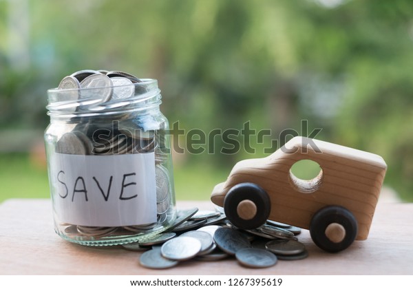 Saving\
money with stack money coin for growing your business,Thai\'s coin\
stacking on wooden texture,saving for good future life,coin stack\
before green background.Saving to buy a new\
car.