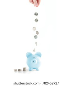 Savings concept. Female hand putting coin into piggy bank isolated on white