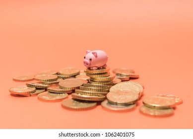 Savings Concept. Micro Piggy Bank On Top Of Coins. Money Concept. Saving For Vacation. Home Finance Concept.