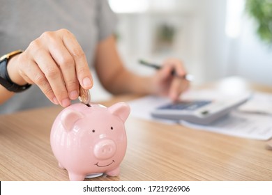 savings and finance concept. woman putting money coin in piggy bank for saving money and plan finance. - Shutterstock ID 1721926906
