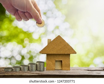 Savings Or Investment For Property, Man's Hand Putting Or Collecting Money For Buy Or Rent House. Investing Or Saving Concept