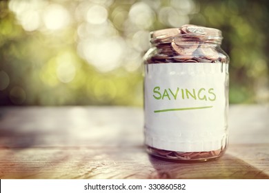 Savings Money Jar Full Of Coins Concept For Saving Or Investment For A House, Retirement Or Education