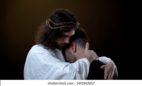 Savior in crown of thrones hugging desperate male, religious peace, forgiveness