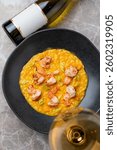 Savor a culinary delight with lobster risotto, bursting with fresh flavors and paired perfectly with crisp chardonnay in an elegant restaurant setting