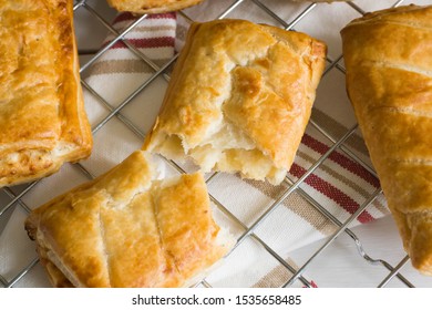 Savory Cheese And Onion Puff Pastry Rolls Fresh Out Of The Oven Cooling On A Cooking Trivet A Vegetarian Alternative To The Usual Sausage Roll