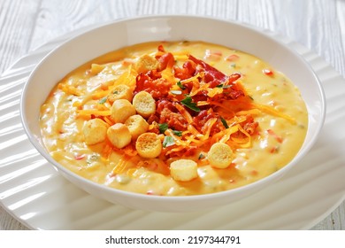 Savory Creamy Pumpkin Soup Topped With Fried Bacon, Shredded Cheddar Cheese And Salty Croutons In White Bowl On Wood Table, Landscape View