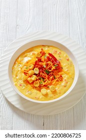 Savory Creamy Pumpkin Soup Topped With Fried Bacon, Shredded Cheddar Cheese And Salty Croutons In White Bowl On Wood Table,vertical View From Above