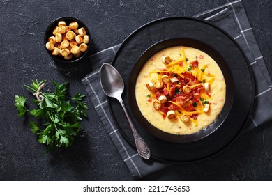 Savory Creamy Pumpkin Soup Topped With Fried Bacon, Shredded Cheddar Cheese And Salty Croutons In Black Bowl On Concrete Table, ,flat Lay,