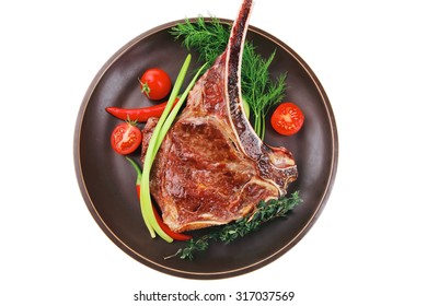 savory : roasted beef spare rib on dark dish with cutlery thyme pepper and tomato isolated over white background
