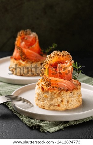 Savory snack cakes, smoked  salmon and vegetable flan or sformatino,  made with cauliflower, leek, egg, ricotta and parmesan cheese. Monoportion  appetizers, dark background, vertical.