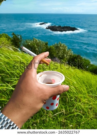 Savour a cup of coffee and a cigarette while enjoying the view from the top of the cliff near the beach.