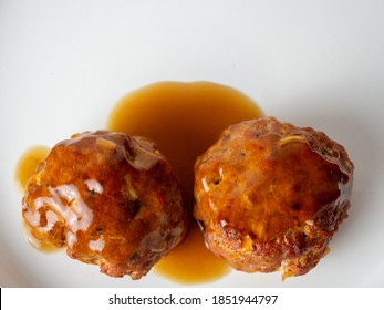 Savoury meatballs served with gravy on white background