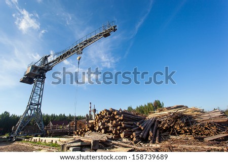 Saw mill with crane and stack of wood