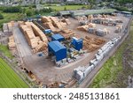 Sawmill with chopped wood logs stacked and machinery