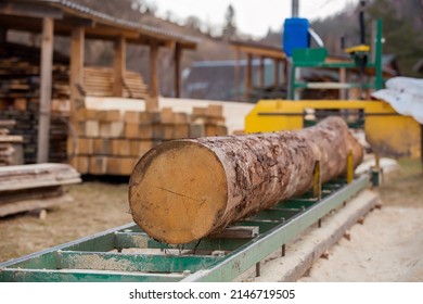 Sawmill. Process Of Machining Logs In Equipment Sawmill. Machine Saw Saws The Tree Trunk On The Plank Boards. Wood Sawdust Work Sawing Timber Wood. Selective Focus