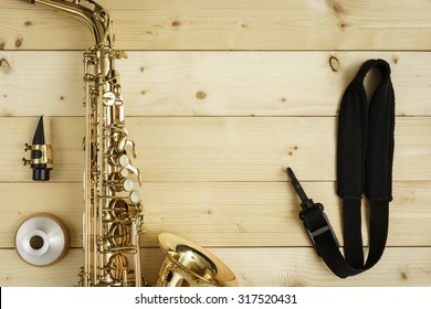 Saxophone On The Wood Background With Strap, Mouse And Mute 